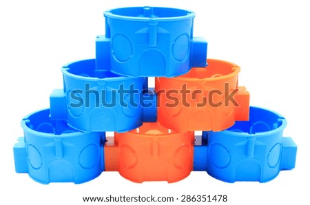 Stack of blue and orange plastic electrical boxes on white background, junction boxes, accessories for engineering jobs