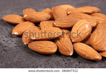 Heap of fresh healthy almonds on structure of concrete, concept for healthy nutrition