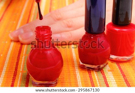 Woman applying red nail polish, manicured nails of woman, nail care