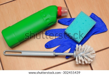 Accessories for cleaning bathroom on ceramics flooring, brush, glove, sponge, concept for house cleaning and household duties