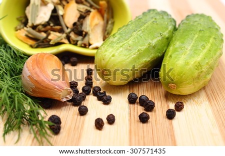 Fresh green cucumbers with spices for pickling cucumbers lying on wooden cutting board