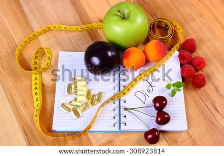 Fresh fruits, tape measure and tablets supplements on notebook for writing notes, choice between healthy eating and slimming pills