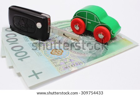 Heap of money, old wooden green toy car and key car. Isolated on white background