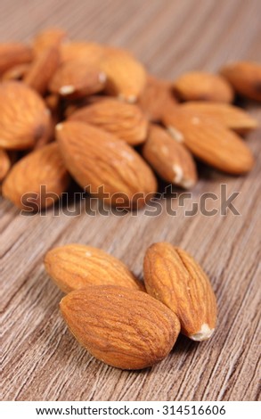 Heap of fresh healthy almonds on wooden background, concept for healthy nutrition