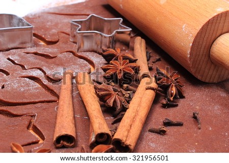 Spice for baking, anise cinnamon sticks and cloves, cookie cutters on dough for Christmas cookies and gingerbread, concept of baking and Christmas time