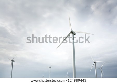 Wind Turbines in wind farm against cloudy sky