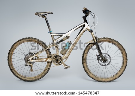 Muddy mountain bike isolated on grey background