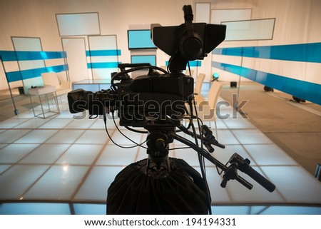 Television studio with jib camera and lights - camera on a crane. Shallow depth of field - focus on camera