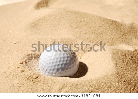 Sunlit golf ball with shadow in unraked sand trap.  Macro with shallow dof.
