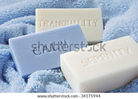 Soft blue and ivory soaps embossed with the words \'calm\', \'serenity\', and \'tranquility\'.  Macro with shallow dof.  Focus on the blue soap.