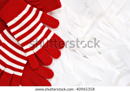 Fun winter background image with red and white knit gloves arranged to include copy space.