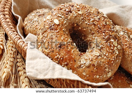 Whole grain wheat bagel in basket with wheat spikes and oats.  Macro with shallow dof.