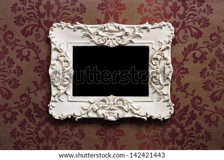 Elegant wooden frame with Victorian style wallpaper as background.