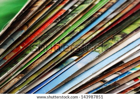 Colorful abstract background image of stacked magazines with slightly worn edges. Macro with extremely shallow dof.