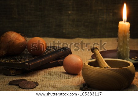 Rural still life with mortar,candle,books and eggs