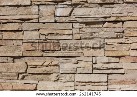Beige wall made of uneven bricks close-up