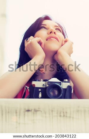 closeup of beautiful young woman holding a vintage camera