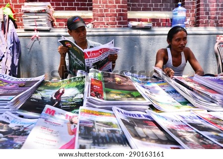 YANGON, MYANMAR - March 27, 2013 : Unidentified men are selling newspaper on the street in Yangon, Myanmar. Yangon is a former capital of Myanmar