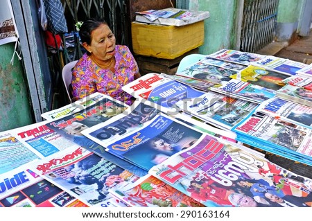 YANGON, MYANMAR - March 27, 2013 : Unidentified woman is selling newspaper on the street in Yangon, Myanmar. Yangon is a former capital of Myanmar