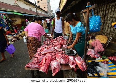 YANGON, MYANMAR - March 24, 2013 : Unidentified woman selling fresh pork at morning market in Yangon. Yangon is the former capital of Myanmar