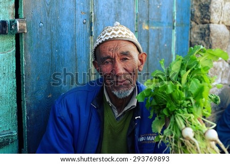 KARGIL, INDIA - June 21, 2012: The old muslim man selling vegetable on the local market of Kargil,Jammu & Kashmir, Northern India.