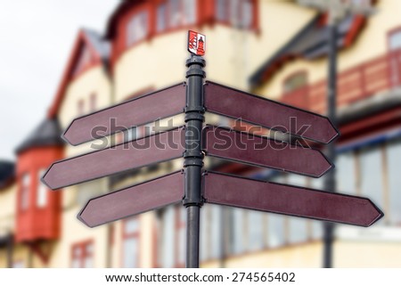 blank signs pointing many directions with old town background