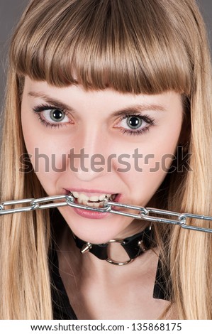 beautiful woman with a chain in teeth