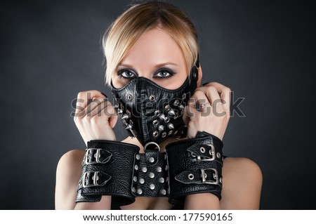 slave woman in handcuffs and a mask with spikes