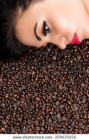 face of a beautiful woman in coffee beans