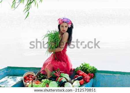 woman in red dress sitting in a boat with vegetables