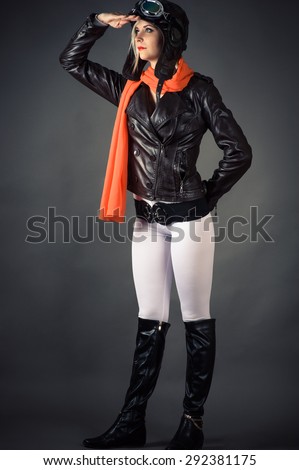 woman looking into the distance in aviator helmet and a red scarf
