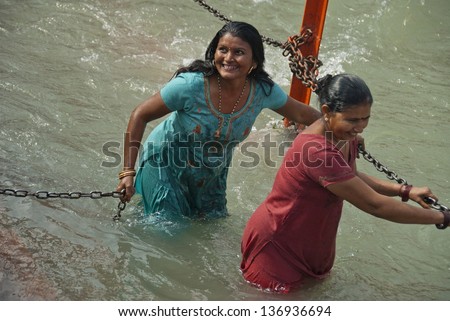 HARIDWAR, INDIA - FEBRUARY 12: Two unidentified Indian women bathe in Ganga river during celebration Kumbha Mela on February 12, 2010 in Haridwar, India. Kumbha Mela is major Hindu festival in India.