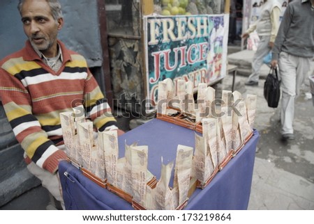 SRINAGAR, INDIA - MAY 4: Unidentified moneychanger offers exchange 10-rupees notes on a street in Srinagar, Indian Kashmir on May 4, 2009. There are a lack of small notes of Indian rupees in Srinagar.