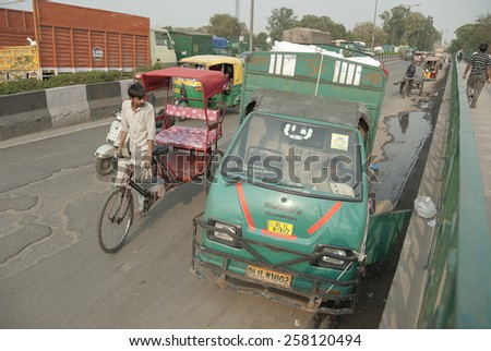 NEW DELHI, INDIA - MARCH 12: Unidentified Indian driver sleeps in the cabin of his truck on a bridge in Delhi, India on March 12, 2014. New Delhi is the busiest city in Asia with unregulated traffic.