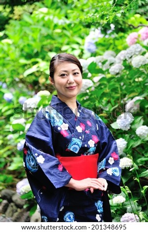 Beautiful Japanese woman standing in the garden blooming hydrangea wearing a kimono