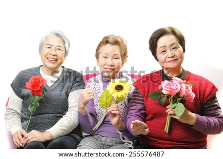 Three elderly women who have a beautiful flower