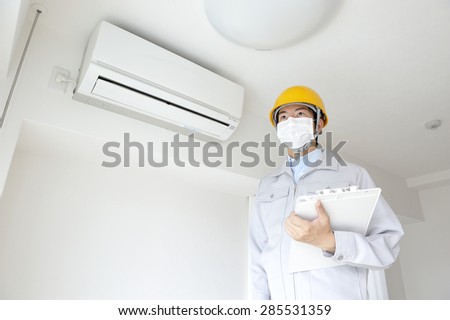 Serviceman wearing the work clothes to inspect air conditioning in the home