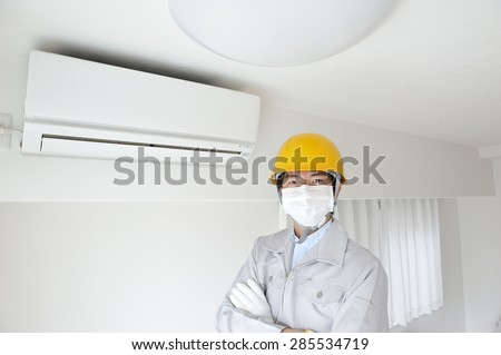 Serviceman wearing the work clothes to inspect air conditioning in the home