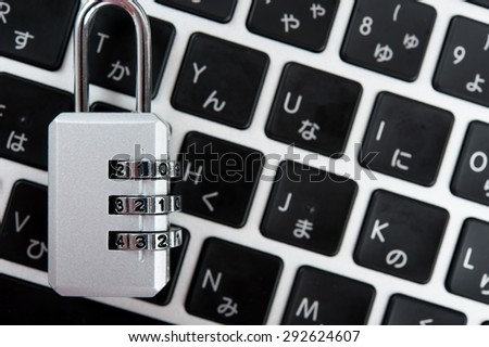 Laptop and silver key, pink background