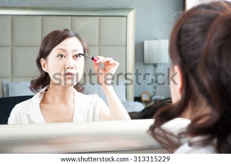 Women who have a makeup to look in the mirror