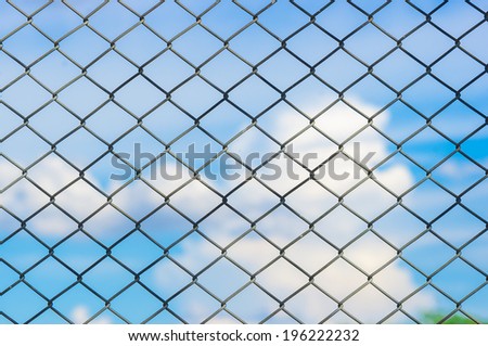 Metal mesh wire fence with blur cloud and blue sky background