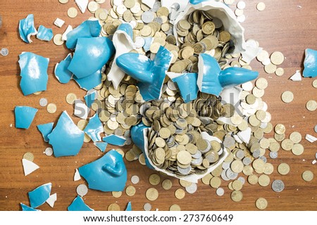 shards of blue ceramic piggy bank pig on a table after breaking full detail