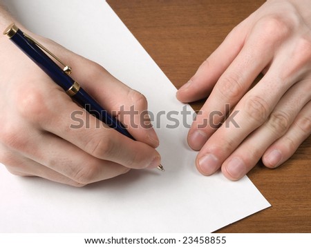 Pen in hand writing on clean paper