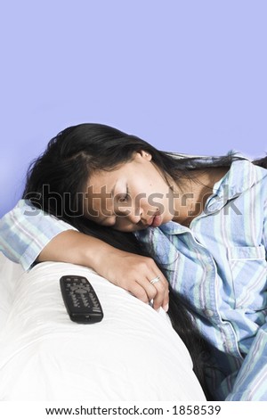woman sleeping on couch with remote aside over blue background