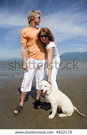 young couple on the beach with dog in vancouver