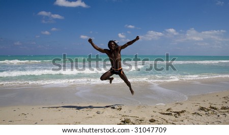 black man jumping on the beach over blue sea and blue sky