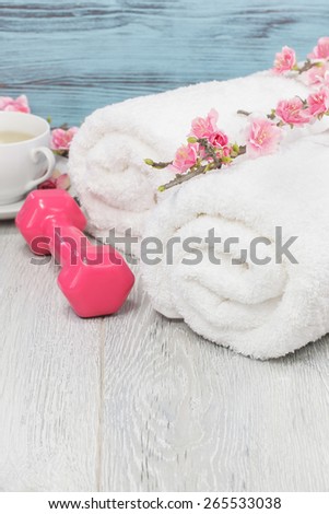Healthy living concept- hand weight, towels and tea. Fitness and healthy living concept with sport- hand weights, towel and tea. Macro photograph with shallow depth of field