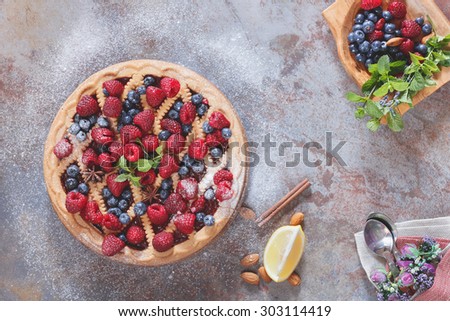 Berry tart with powdered sugar on top. Fresh summer  raspberry blueberry tart with a shortbread crust, top view