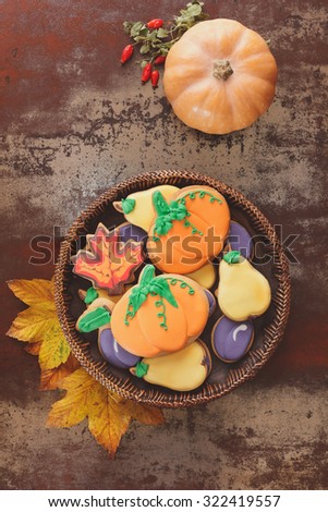 Thanksgiving cookies  and squash  on rustic table.  Thanksgiving cookies in the shape of pumpkin, pear, plum and leaves. Fall decorated cookies