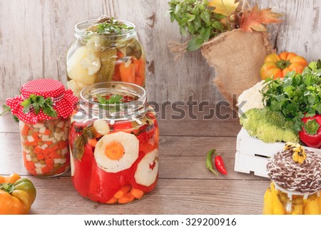 Pickled vegetables. Still life with several jars of pickled vegetables and herbs. Vintage style